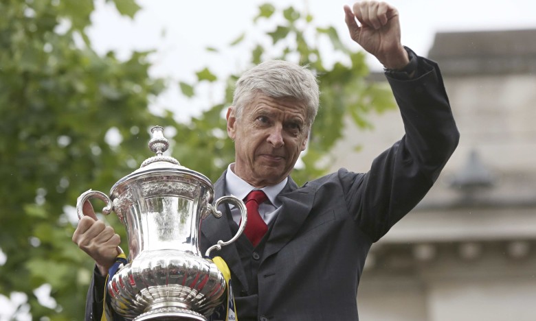 The Arsenal manager Arsene Wenger holds the FA Cup during Sunday's victory parade in north London.